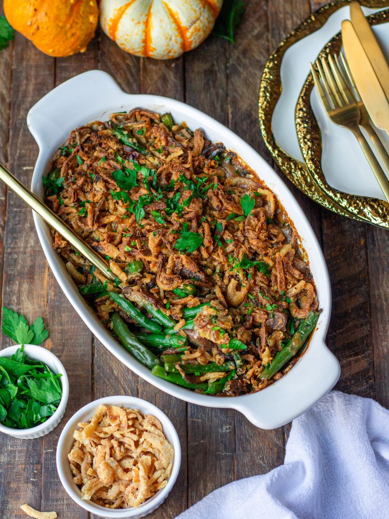 Golden baked Vegan Green Bean Casserole topped with crispy onion strings and fresh parsley.