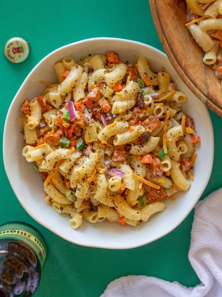 Bowl of Vegan Filipino-Style Macaroni Salad with vegetables, pineapple, and plant-based hot dogs.