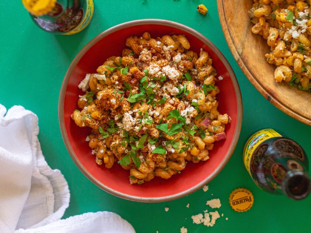 Bowl of colorful Vegan Street Corn Pasta Salad with roasted corn, red onion, and cilantro