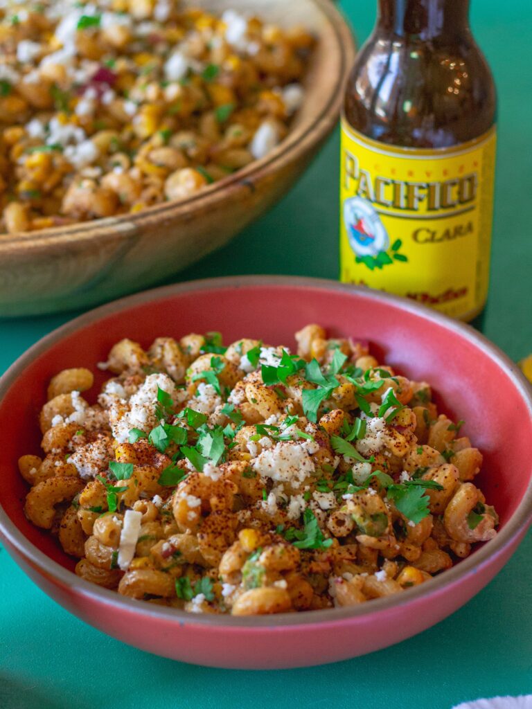 Bowl of colorful Vegan Street Corn Pasta Salad with roasted corn, red onion, and cilantro