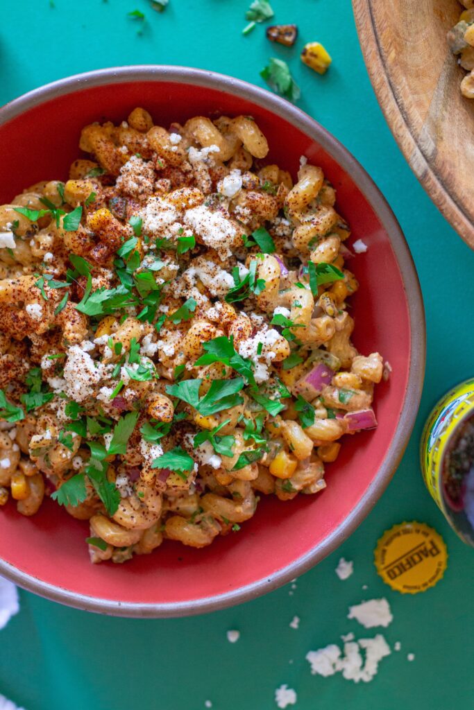 Bowl of colorful Vegan Street Corn Pasta Salad with roasted corn, red onion, and cilantro