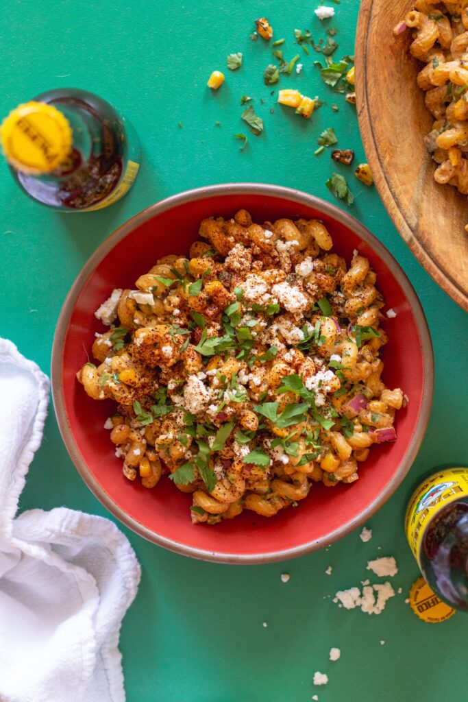 Bowl of colorful Vegan Street Corn Pasta Salad with roasted corn, red onion, and cilantro