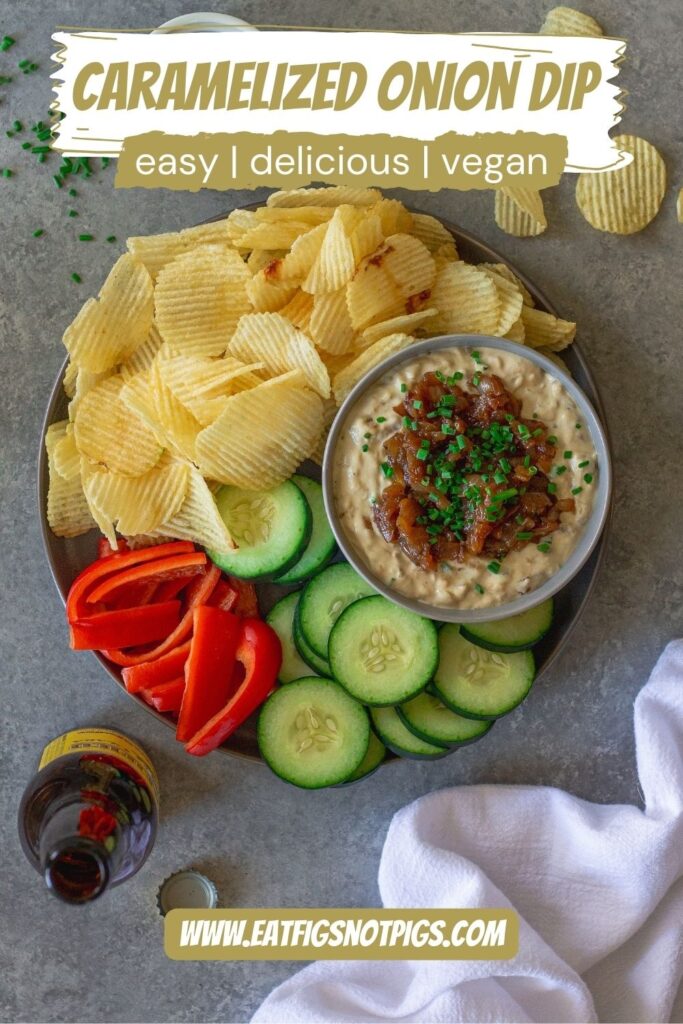 Vegan caramelized onion dip served on a platter with chips and fresh vegetables, perfect for dipping.