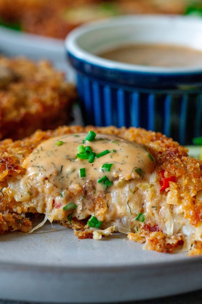 Close-up of the inside of a vegan crab cake, revealing a flaky, crab-like texture made from hearts of palm and vegetables.