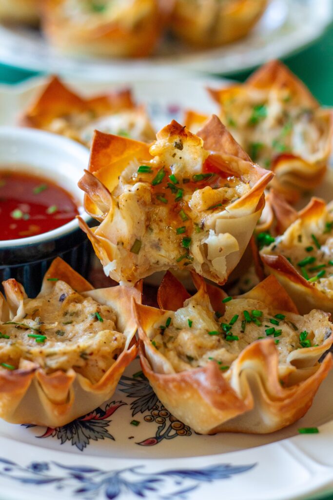 Plate of Vegan Crab Rangoon Wonton Cups served with sweet chili sauce for dipping.