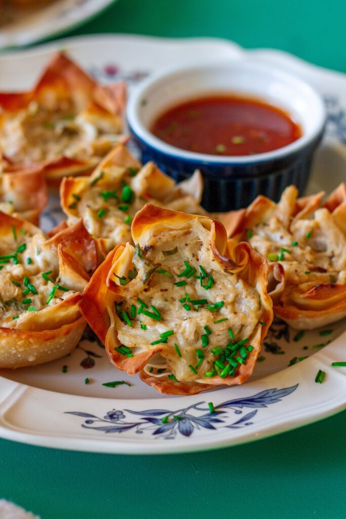 Plate of Vegan Crab Rangoon Wonton Cups served with sweet chili sauce for dipping.