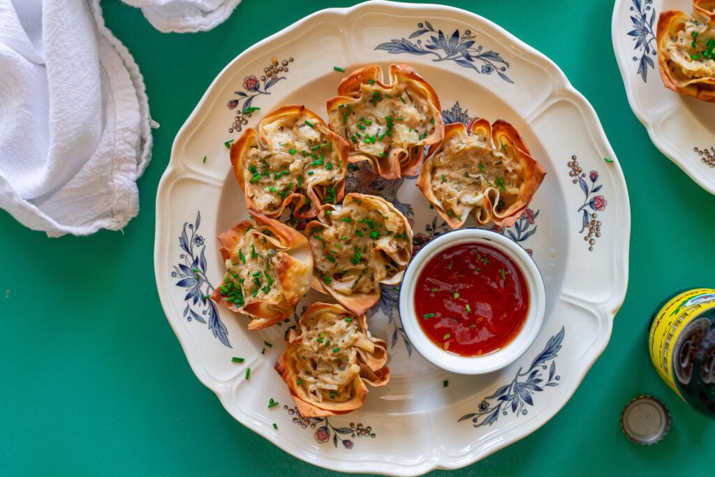 Plate of Vegan Crab Rangoon Wonton Cups served with sweet chili sauce for dipping.