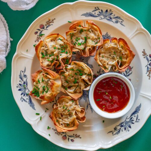 Plate of Vegan Crab Rangoon Wonton Cups served with sweet chili sauce for dipping.