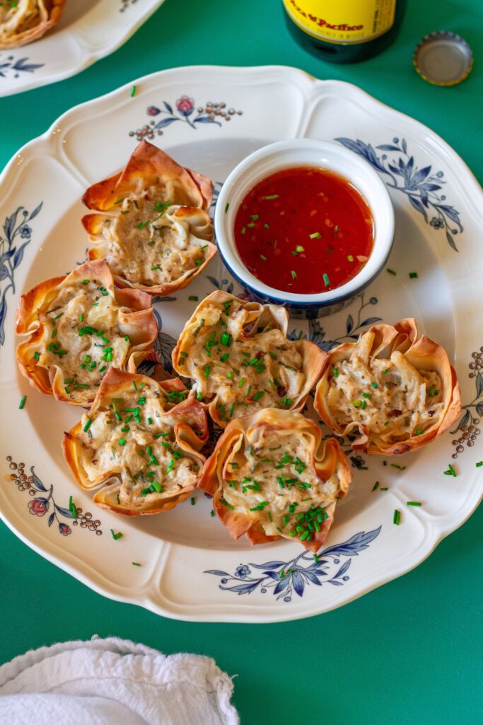 Plate of Vegan Crab Rangoon Wonton Cups served with sweet chili sauce for dipping.