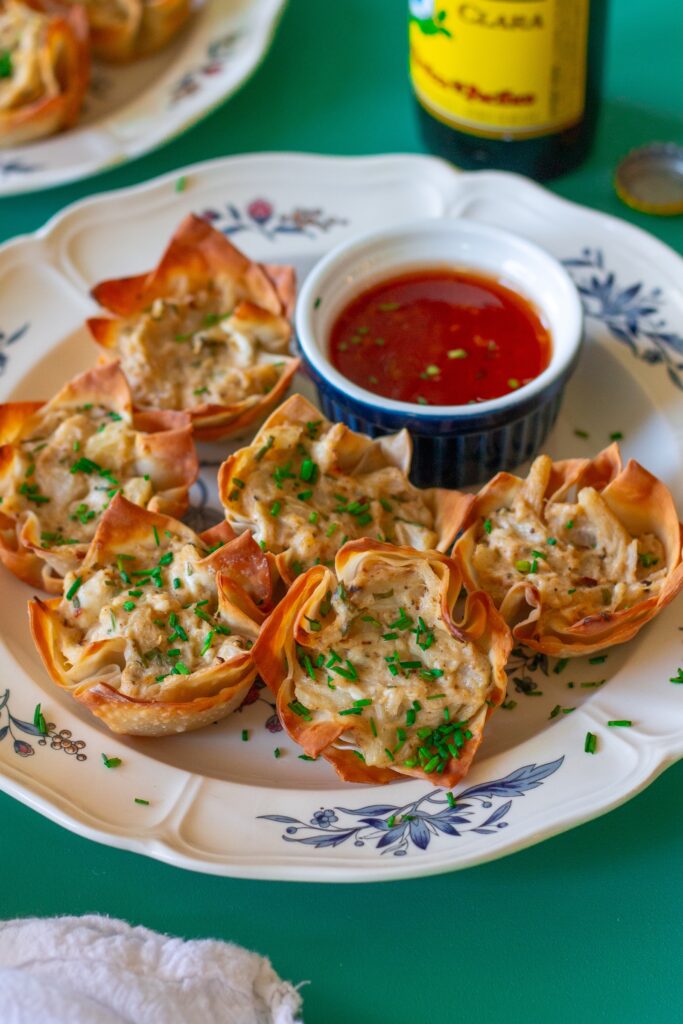 Plate of Vegan Crab Rangoon Wonton Cups served with sweet chili sauce for dipping.