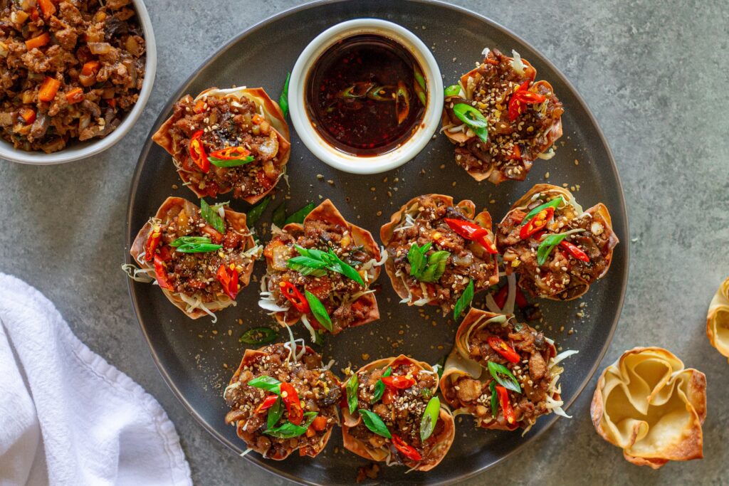 Finished Lettuce Wrap Inspired Wonton Cups garnished with green onions and sesame seeds, ready to serve.