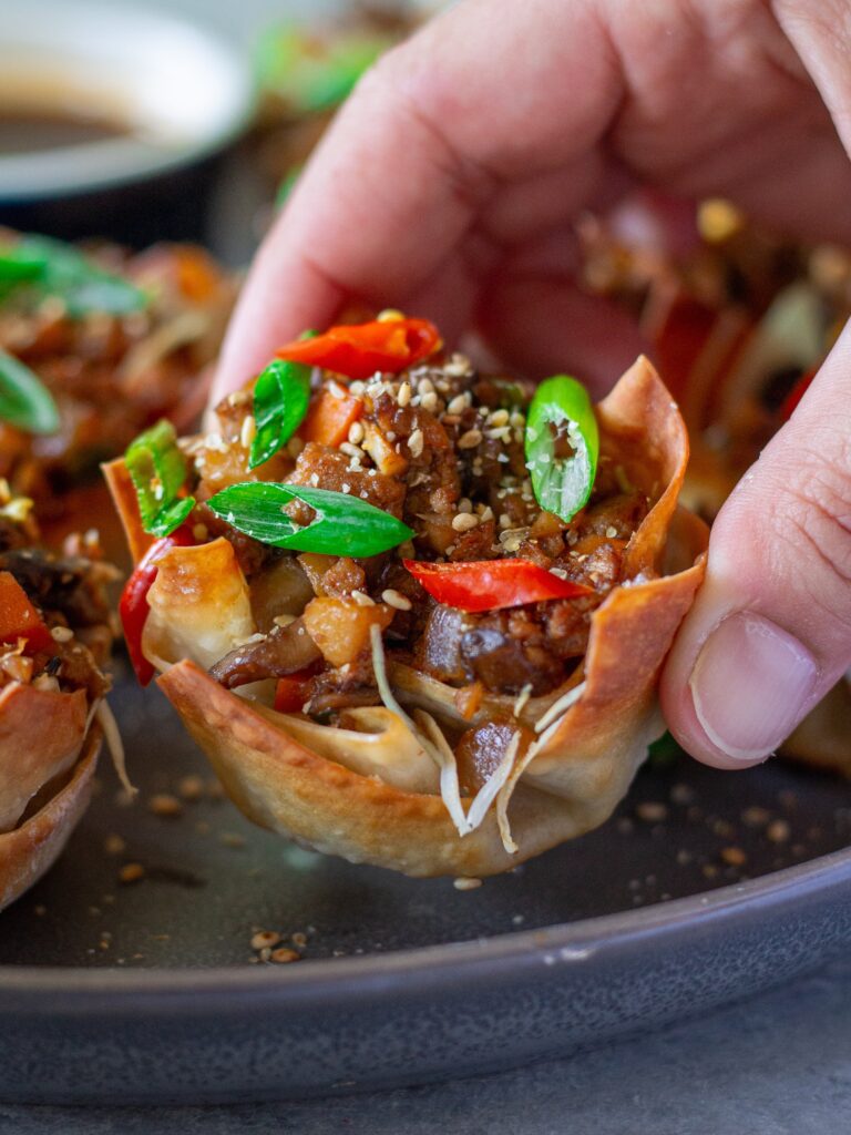 Finished Lettuce Wrap Inspired Wonton Cups garnished with green onions and sesame seeds, ready to serve.