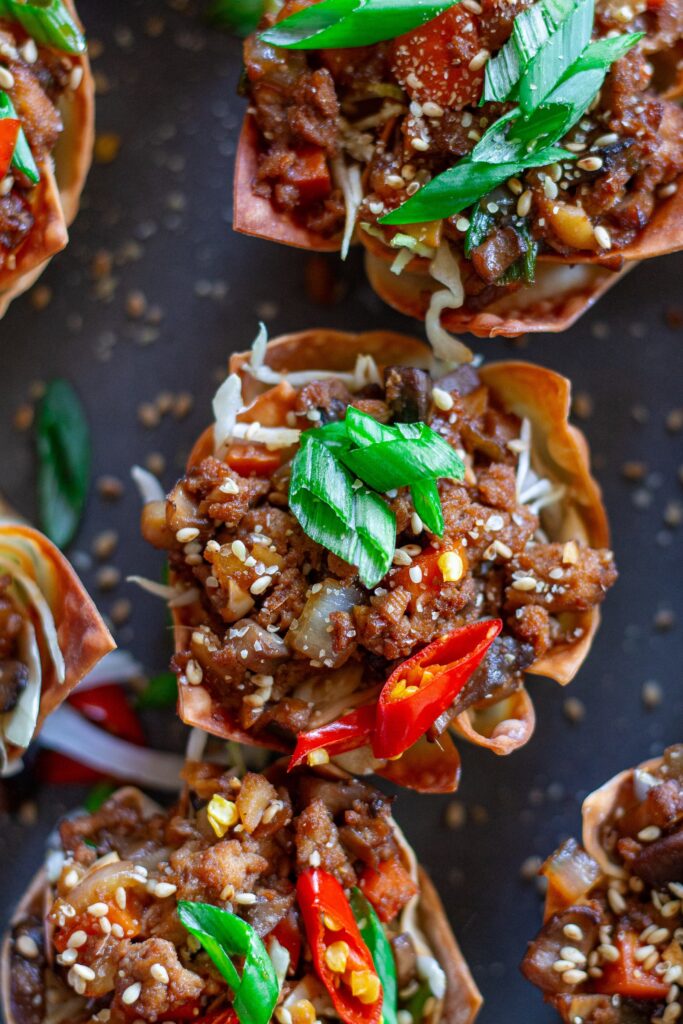 Finished Lettuce Wrap Inspired Wonton Cups garnished with green onions and sesame seeds, ready to serve.