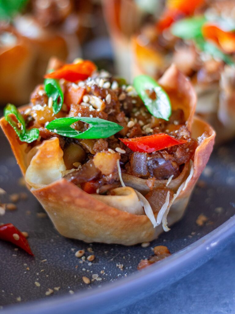 Finished Lettuce Wrap Inspired Wonton Cups garnished with green onions and sesame seeds, ready to serve.