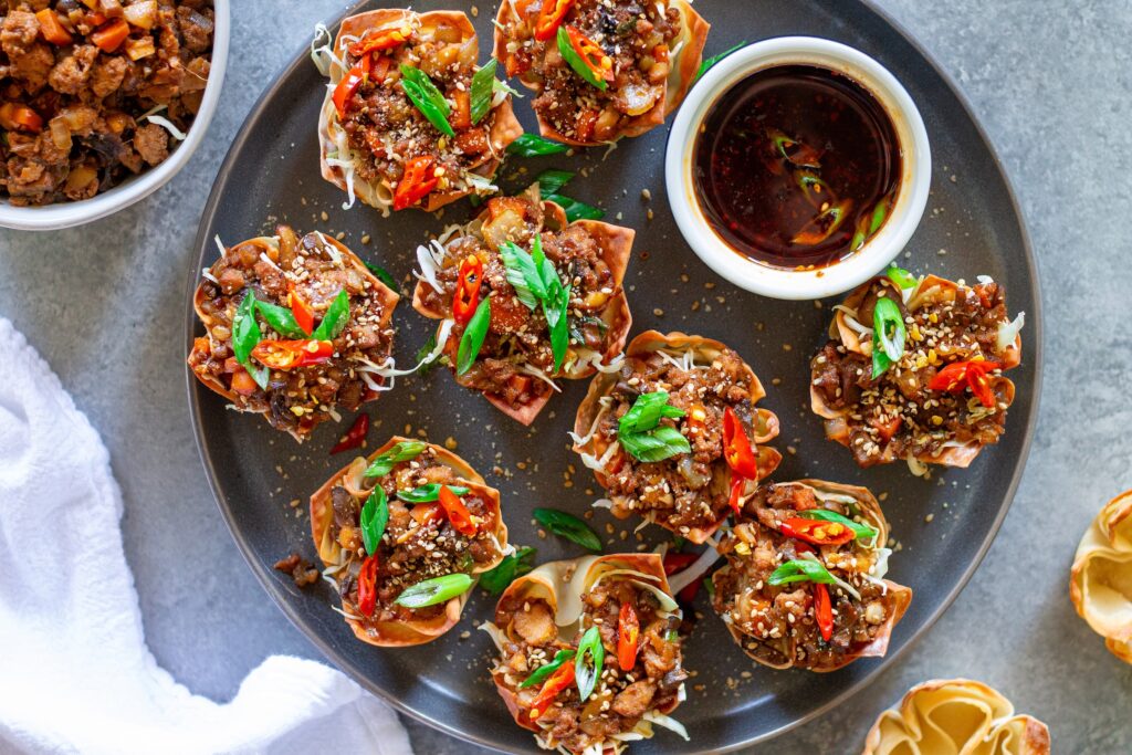 Finished Lettuce Wrap Inspired Wonton Cups garnished with green onions and sesame seeds, ready to serve.