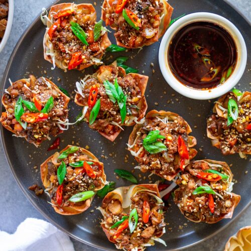 Finished Lettuce Wrap Inspired Wonton Cups garnished with green onions and sesame seeds, ready to serve.